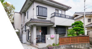 2階建ての介護施設の外観。白壁の建物に木製フェンスが付いている